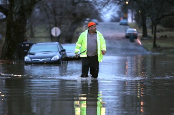 This road in Muncie, Ind., was among those flooded out on Monday. Resident Mark Coatie was attempting to clear drains near his house after the area received over three inches of rainfall.